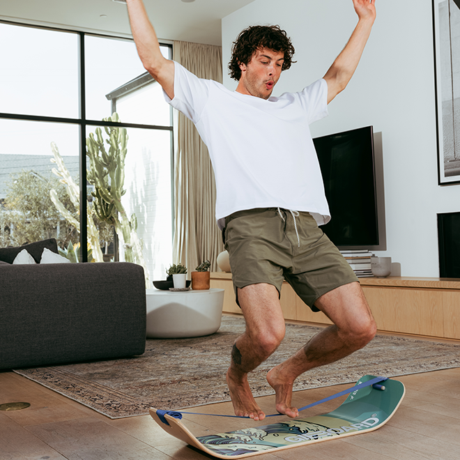 Man performing a trick on a waves slackboard indoors