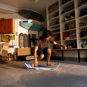 Person working on a mountain slackboard in a garage with shelves and tools in the background