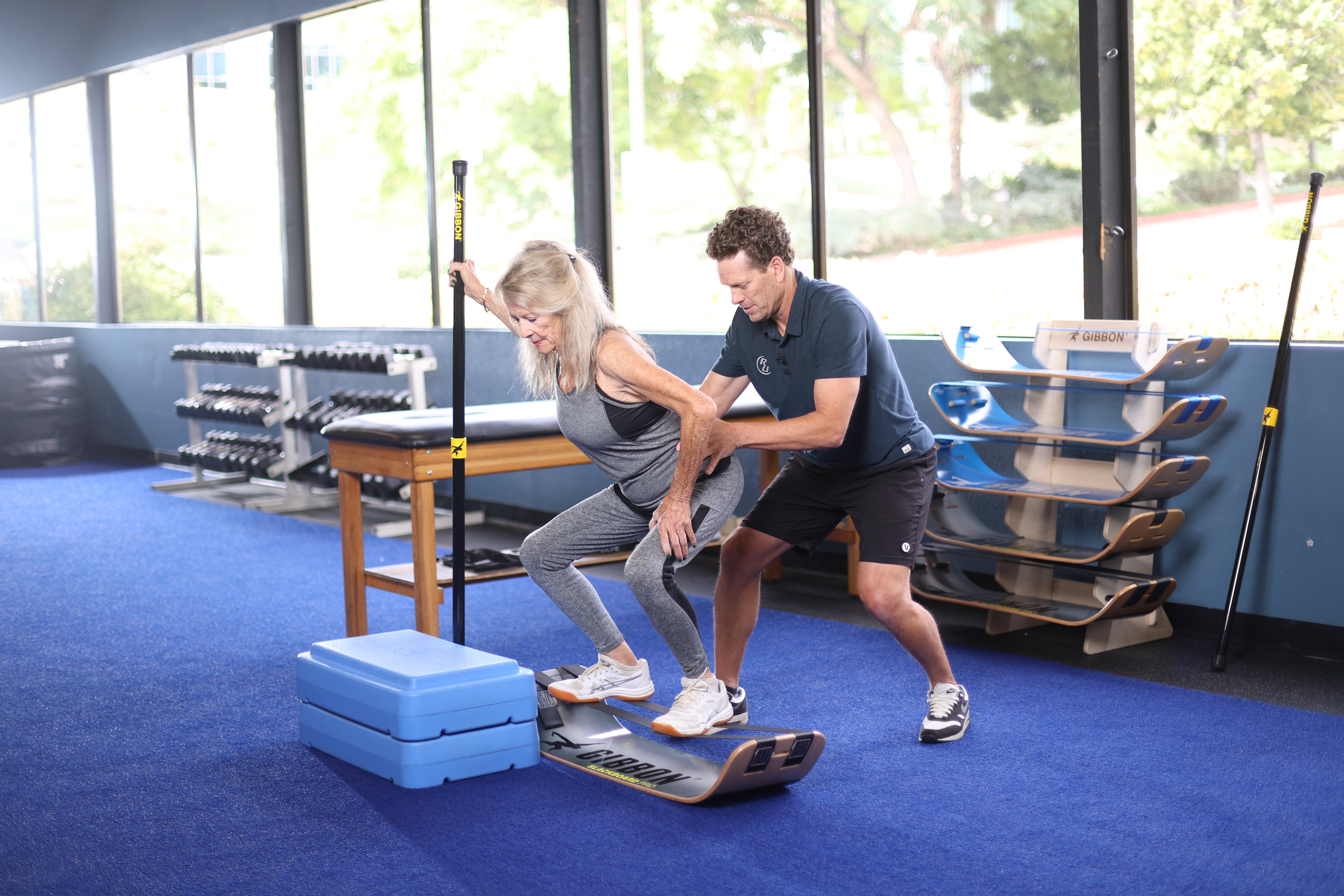 A physical therapist guiding a patient on a GIBBON SlackBoard